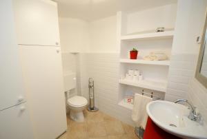 a white bathroom with a toilet and a sink at Holiday Home Nono Frane in Lindar