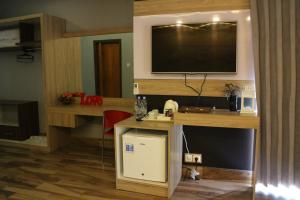 a room with a desk with a television on a wall at Lawaka Hotel in Ampana