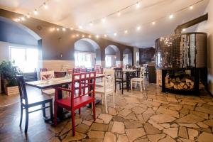 a restaurant with tables and chairs and a fireplace at Mozaikowy Piec in Ślesin