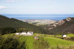 a house on a hill with the ocean in the background at El Vallín de Alba in La Artosa