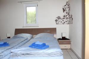 Dos camas en un dormitorio con toallas azules. en Bungalow Groß Dratow, en Groß Dratow