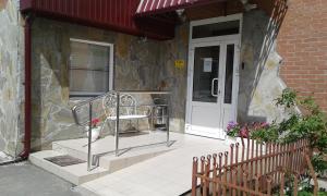 a porch of a house with a bench next to a door at Vysotnik Hotel in Chelyabinsk