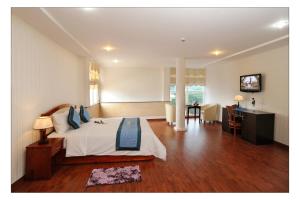 a bedroom with a bed and a desk and a television at Song Thu hotel in Danang