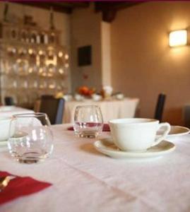 a table with two glasses and a bowl and a cup at Relais Du Vignoble in Gueberschwihr