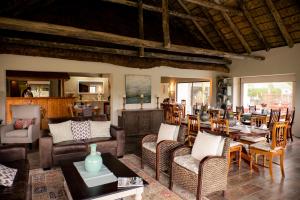 sala de estar con muebles y mesa. en De Old Drift Guest Farm en Addo