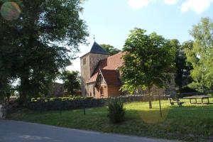 ein altes Gebäude mit einem Turm und einer Kirche in der Unterkunft Bungalow Groß Dratow in Groß Dratow
