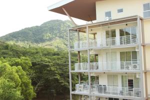 a building with balconies and a mountain in the background at Pico De Loro Condo Unit in Nasugbu