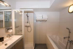 a bathroom with a shower, sink, and tub at Vlierijck in Oost-Vlieland