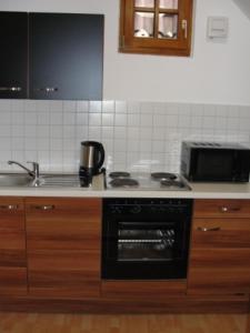 a kitchen with a stove top oven and a microwave at The Square Coburg in Coburg