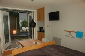 1 dormitorio con cama, mesa y comedor en B&B EINDHOVENnearby, en Waalre
