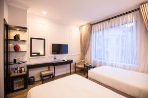 Ένα ή περισσότερα κρεβάτια σε δωμάτιο στο Dinh Elegant Hanoi Hotel
