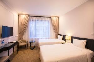 Ένα ή περισσότερα κρεβάτια σε δωμάτιο στο Dinh Elegant Hanoi Hotel