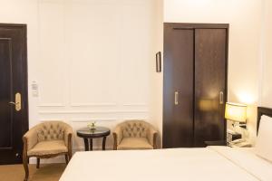 Ένα ή περισσότερα κρεβάτια σε δωμάτιο στο Dinh Elegant Hanoi Hotel