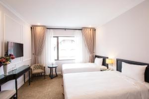 Ένα ή περισσότερα κρεβάτια σε δωμάτιο στο Dinh Elegant Hanoi Hotel