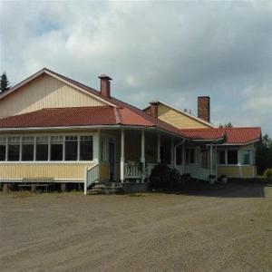 ein Haus mit rotem Dach und vielen Fenstern in der Unterkunft Majatalo Myötätuuli in Pitkäjärvi