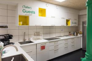 a kitchen with white cabinets and white appliances at Winstrup Hostel in Lund