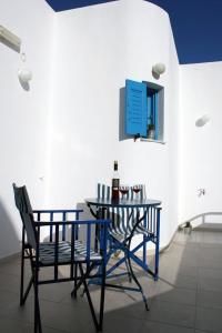 a table with two chairs and a bottle of wine at Semprou Rooms in Perissa