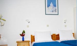 sypialnia z dwoma łóżkami i wazonem na stole w obiekcie Semprou Rooms w mieście Perissa