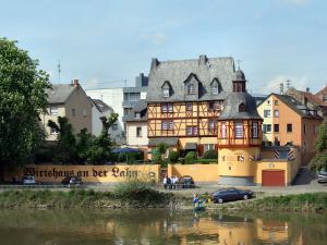 a large building next to a body of water at Pension Historisches Wirtshaus an der Lahn in Lahnstein