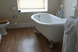 a bathroom with a white tub and a toilet at Trearddur Bay Hotel in Trearddur