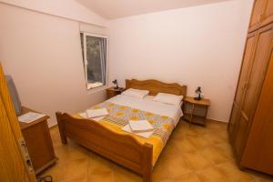 a bedroom with a bed with two tables and a window at Apartments De Lara in Utjeha