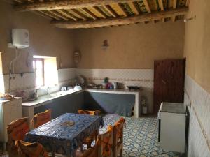 eine Küche mit einem Tisch, einem Tisch und Stühlen in der Unterkunft Gîte d'étape traditionnel berbère in Ifri