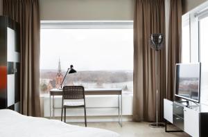 a bedroom with a desk and a large window at Comfort Hotel Winn in Umeå