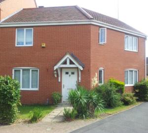 a red brick house with a white door at Newstead House in Banbury