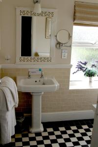 a bathroom with a sink and a mirror and a window at Trearddur Bay Hotel in Trearddur