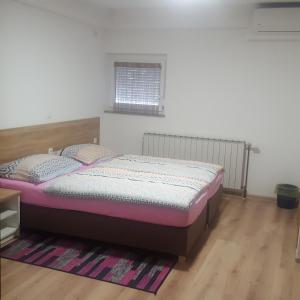 a bedroom with a bed and a rug at Sobe Mrak in Bjelovar