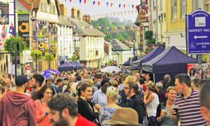 una folla di persone che camminano per una strada trafficata di Hardwick Farm ad Abergavenny
