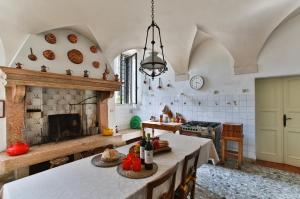 a large kitchen with a table and a fireplace at LA SERENELLA West Wing in San Pietro in Cariano