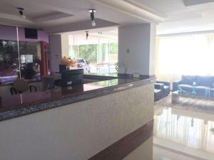 a kitchen with a counter and a living room at Di Roma Rio Quente in Rio Quente +13 photos