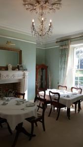 a dining room with tables and chairs and a chandelier at Cannaway House B&B in Macroom