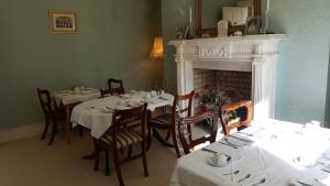 a dining room with tables and chairs and a fireplace at Cannaway House B&B in Macroom