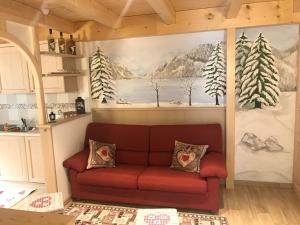 a couch in a living room with a painting on the wall at Genzianella Mansarda Molveno-Andalo in Molveno