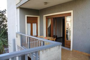 un balcone di una casa con porta in legno di B&B 5 Sensi a Belpasso