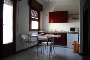 una cucina con tavolo e sedie in una stanza di B&B 5 Sensi a Belpasso Altre 21 foto
