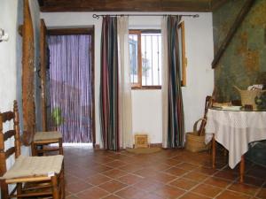 sala de estar con mesa y 2 ventanas en Casa La Chelva, en Alcudia de Veo