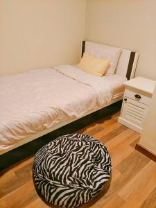 a bed with a zebra print ottoman in a room at My Resort Hua Hin in Hua Hin