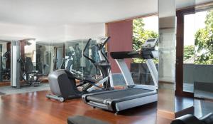 a gym with a treadmill and elliptical machines at Amnaya Resort Kuta in Kuta