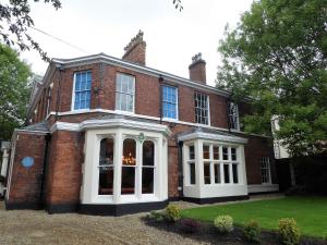 a large red brick house with white doors at The Smeaton at Claremont Apartments in Leeds
