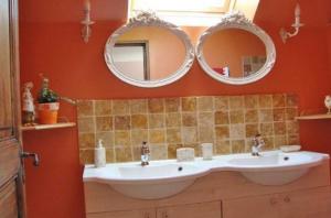 La salle de bains est pourvue de 2 miroirs et d'un lavabo. dans l'établissement Chambres d'hôtes Aux Portes de Bréhat, à Ploubazlanec