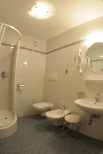 a bathroom with a sink and a toilet and a tub and sink at Hotel Lengsteinerhof in Longostagno