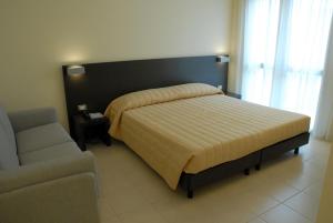 a bed in a room with a couch and a bed sidx sidx sidx at San Giorgio Hotel in San Giórgio di Nogaro
