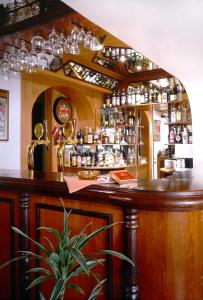 a bar with a lot of glasses on a shelf at Hotel Lux in České Budějovice