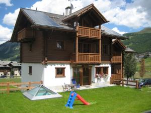 a house with a playground in front of it at Chalet Nada in Livigno