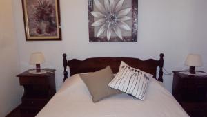 Un dormitorio con una cama con dos mesitas de noche y dos lámparas. en apartman house Bjedov, en Povlja