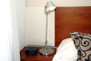 a lamp sitting on a table next to a bed at Palm Beach Plaza Hotel in Montevideo