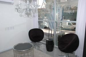a room with two black chairs and a window at Palm Beach Plaza Hotel in Montevideo